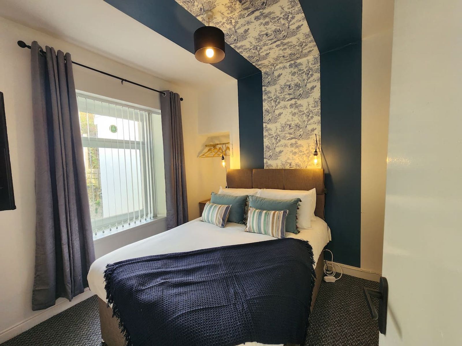 A KG-staged bedroom with feature wallpaper